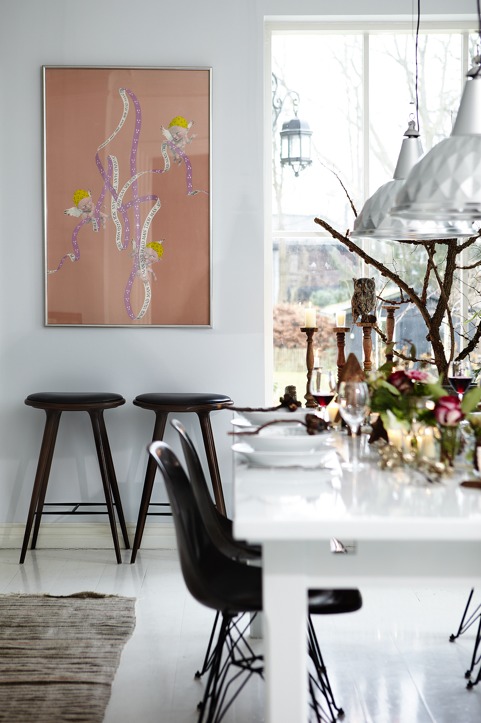 The dining space is accented with black chairs, candles, florals and catchy pendant lamps