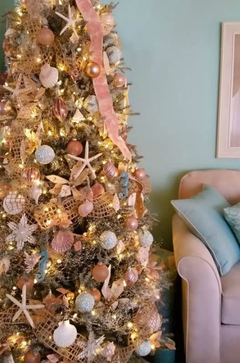 a different coastal Christmas tree with pinks, glitter, metallics, starfish and nets is a very creative idea