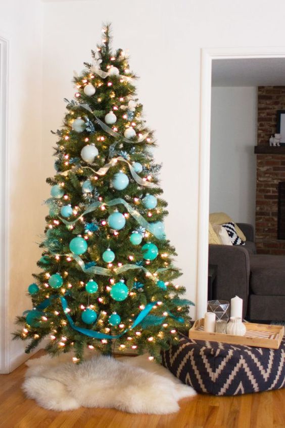 a bold ombre Christmas tree from white to turquoise and blue with lights and ribbons is ideal for a beach Christmas