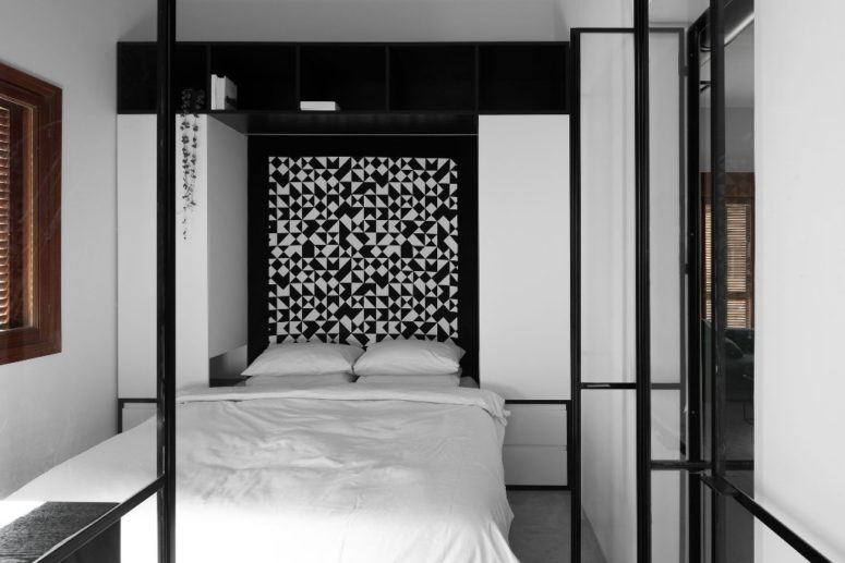 The master bedroom features a bold geometric headboard, a large bed and enough storage space