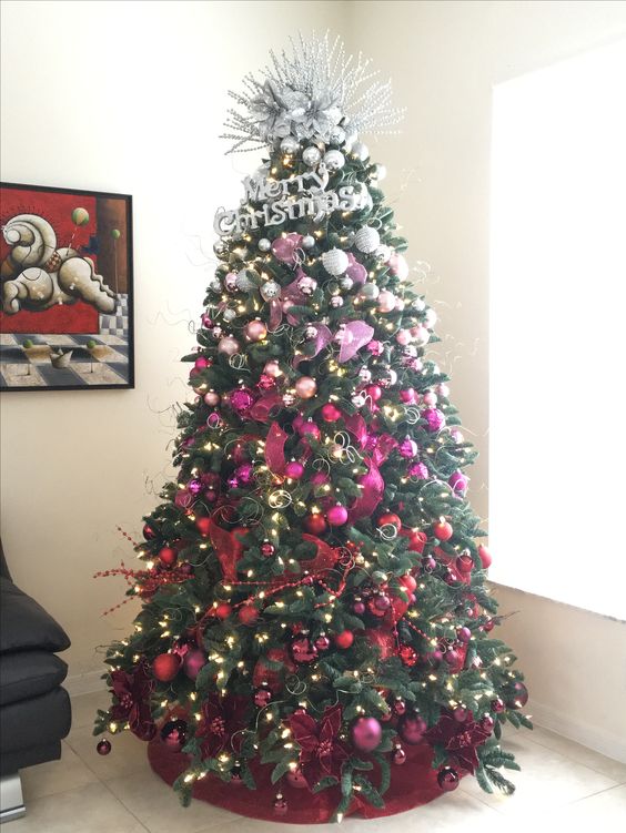 a bold ombre silver to pink and red Christmas tree with lights, fabric flowers and bows plus a creative topper