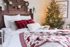 06 a cozy traditional bedroom with pompom garlands, a lit up Christmas tree and red and white bedding