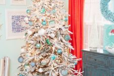06 a flocked Christmas tree with float-like ornaments, lights, star fish features strong coastal vibes