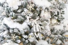06 a flocked Christmas tree with ornaments of all kinds, fake blooms and faux fur in white brings you to winter wonderland