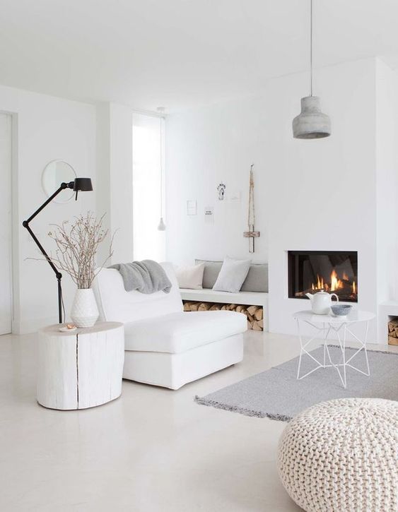 a minimalist Nrodic living room in white, off-whites and greys plus a cozy built-in fireplace