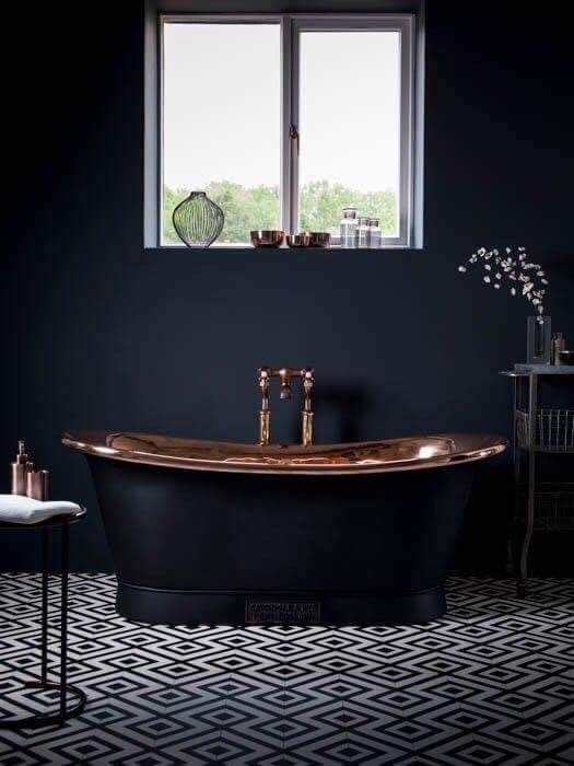 a moody bathroom with a fantastic black bathtub with a copper surface inside is a gorgeous idea