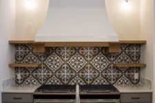 06 a mosaic tile backsplash and a vintage kitchen hood bring Mediterranean vibes to the space