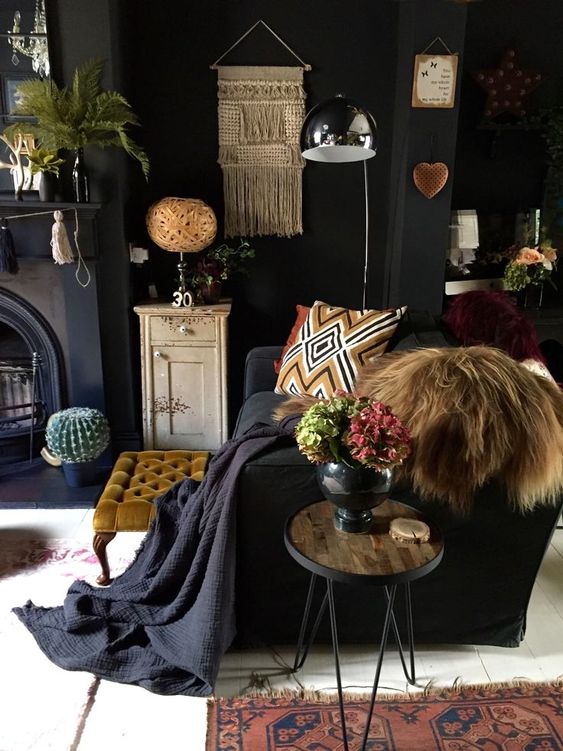 a dark eclectic living room with contemporary furniture and vintage and boho accessories and items