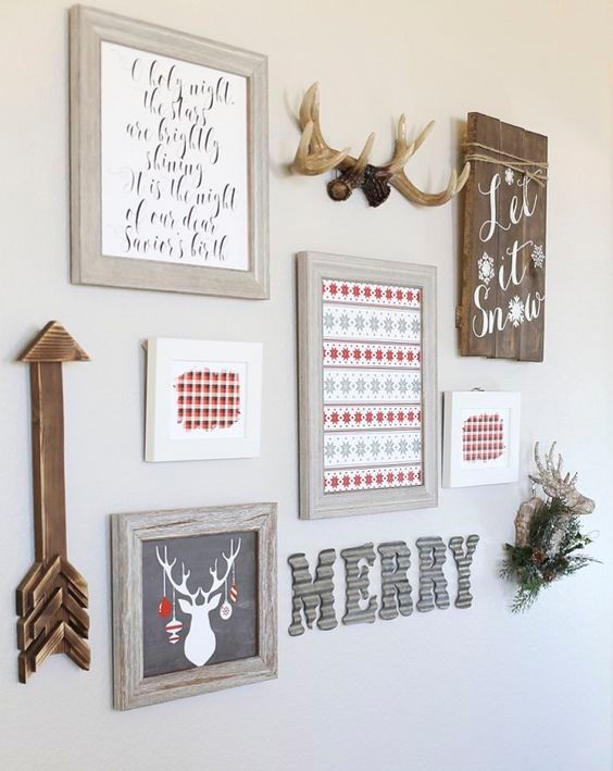 a holiday gallery wall with signs, letters, artworks, a fake deer head and an arrow for Christmas