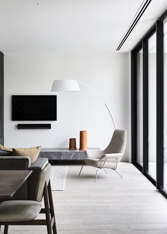 a minimalist living room with quirky and stylish furniture and much natural light comfing through a glazed wall