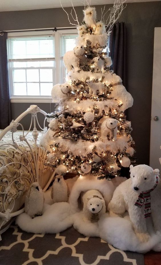 a kid's Christmas tree decorated with polar bears, white snowy ornaments, lights and even penguins is a whimsy idea