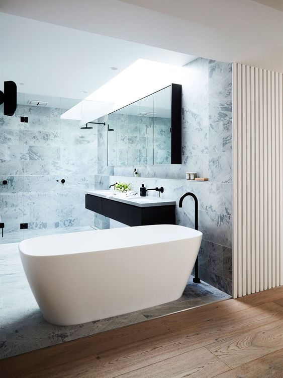 a minimalist bathroom with a comfy free-standing bathtub and marble tiles for a chic look