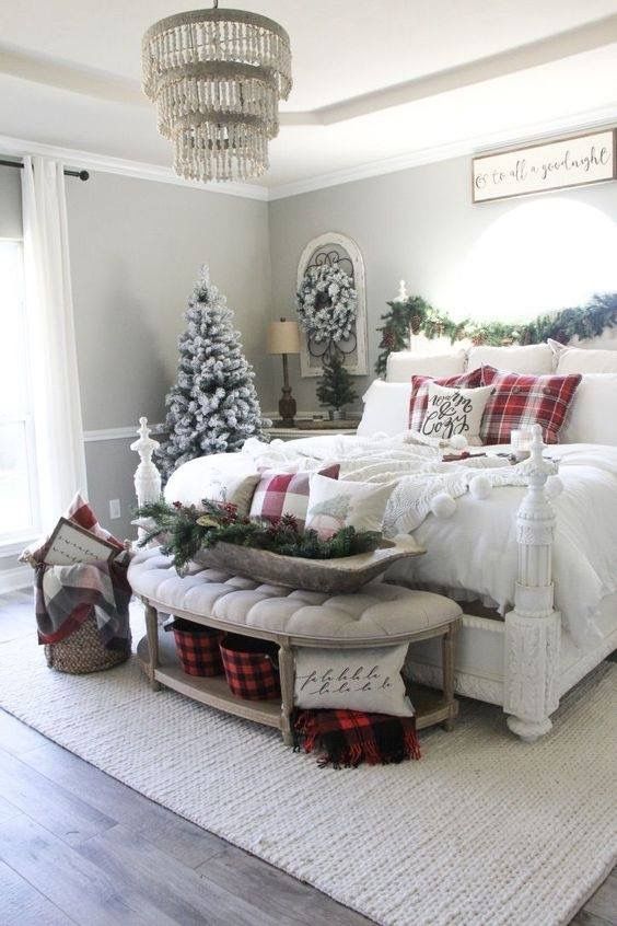 a farmhouse Christmas bedroom with evergreens, a flocked tree and wreath, a dough bowl with evergreens and plaid