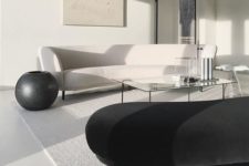 09 a minimal living room with black and white sofas, much natural light and glass coffee tables
