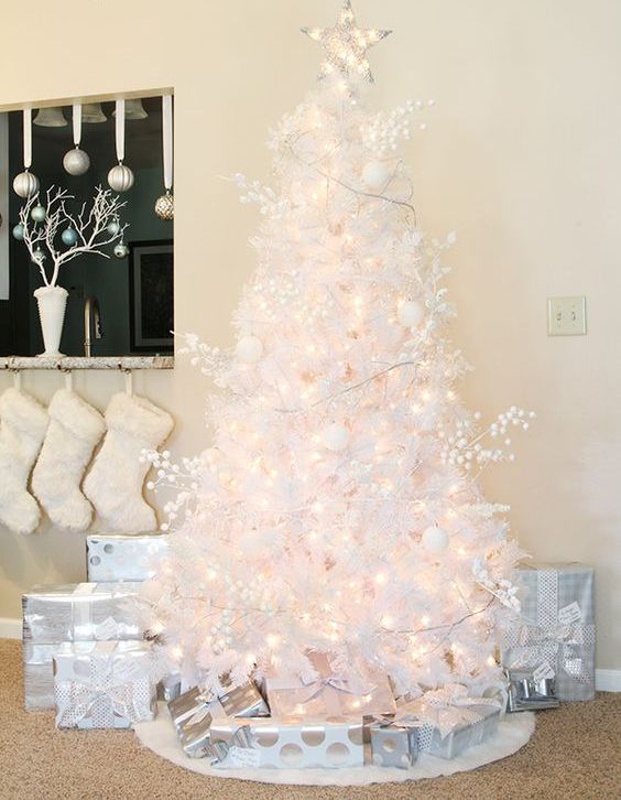 a pure white Christmas tree decorated with lights, branches, ornaments and lights seems very airy and beautiful