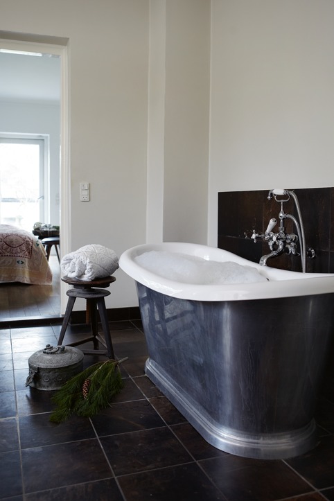 The bathroom is done in black and white, with some vintage stuff and a large galvanized bathtub