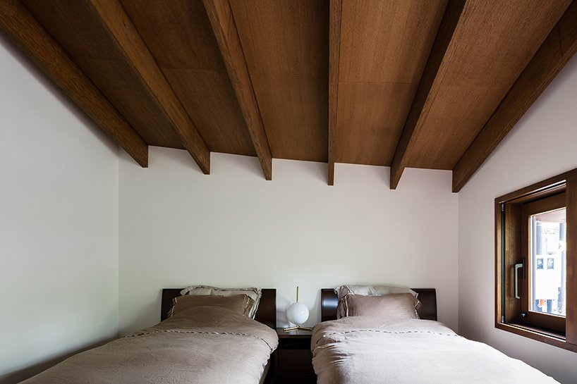 The guest bedroom is a shared one, its laconic decor features two beds and an attic roof