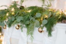 10 an evergreen wreath and a matching garland with lights and gold Christmas ornaments hanging down