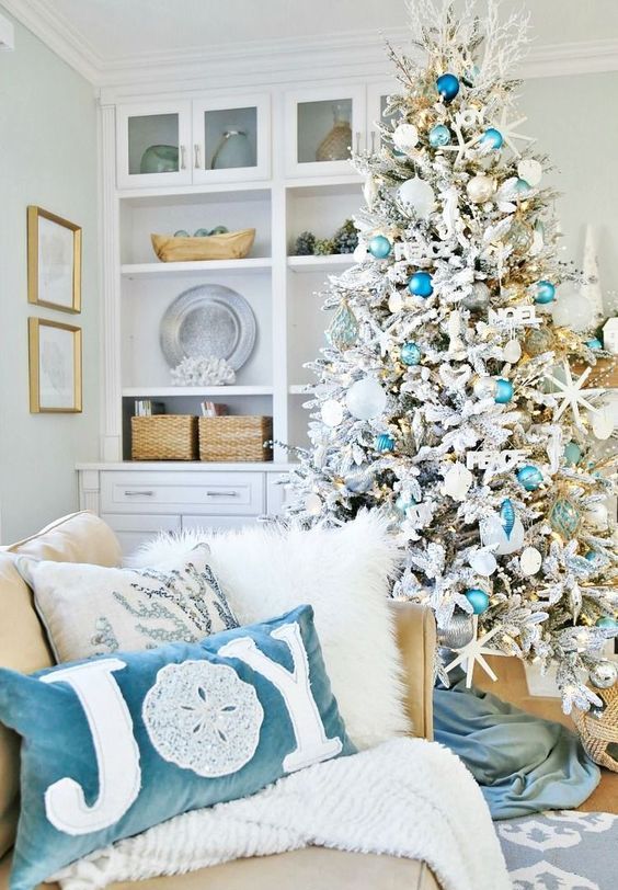 a chic flocked Christmas tree with turquoise and blue ornaments, star fish and fake corals, matching pillows