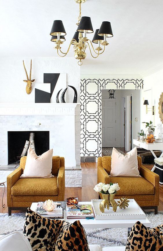 an eclectic living room done in black, gold, white as a cohesive color scheme for decor
