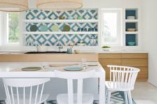 11 blue and white mosaic tiles clad the backsplash and the floor bring strong Mediterranean vibes to the kitchen