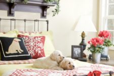 12 a colorful sleeping space with mustard and plaid bedding, an evergreen garland and wreath, red blooms