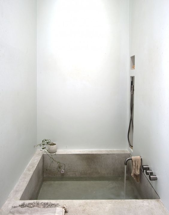a concrete bathtub is a cool idea to rock in a minimalist bathroom, it's durable and comfortable