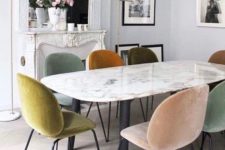 12 same chairs in mismatched muted tones make this dining space much more interesting