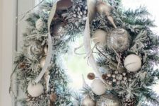 13 a silver Christmas wreath with snowy pinecones and a bow on top is a chic idea for Christmas decor