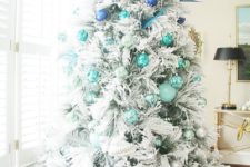 13 a snowy Christmas tree decorated with ornaments from bright blue to turquoise and silver grey for an ombre effect