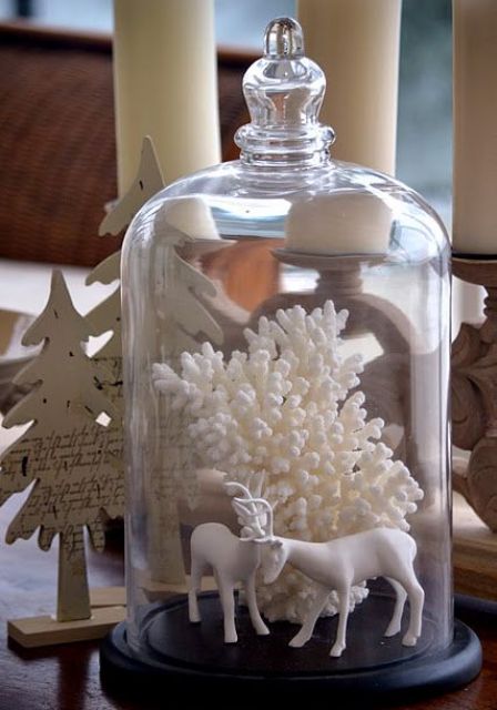 a cloche with deer figurines and corals scream coasts and Christmas at the same time