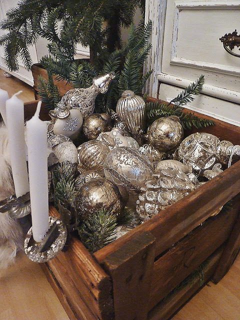 a crate filled with vintage silver ornaments and evergreens is great for any space if your tree can't accommodate them