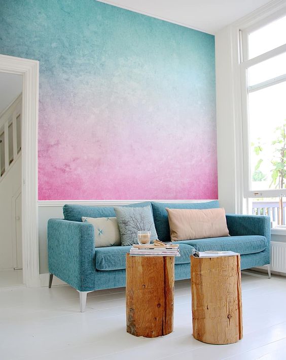 a statement gradient wall in blue and pink plus a matching sofa is a cool idea to impress with bold tones