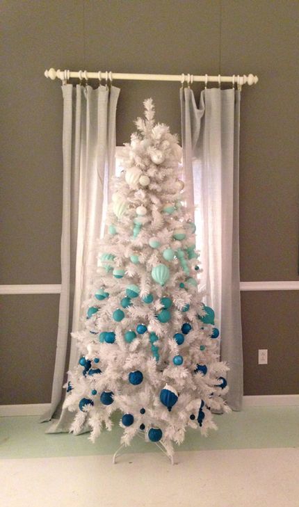 a white Christmas tree with ornaments to achieve an ombre effect from silver to turquoise and navy looks freezing