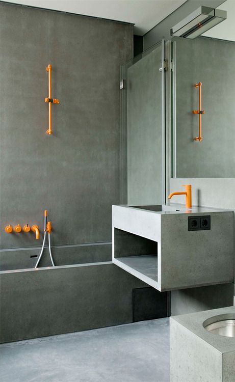 accent your concrete bathroom with bright orange textures to make it more cheerful and vivacious