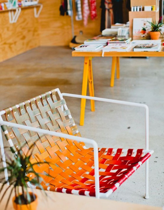 a bright leather belt chair from neutral to orange and deep red is a cool piece for a boho or mid-century modern space
