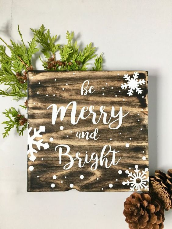 a snowy Christmas sign decorated with evergreens is an easy and very cozy holiday craft