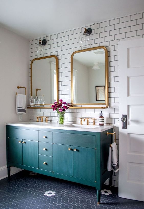 a modern and bold bathroom done with subway tiles with black grout and a bright emerald vanity