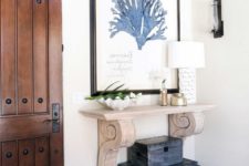 18 a wood carved console and a stack of vintage chests make the entryway really beachy and Mediterranean