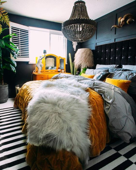 a colorful bed is a statement in this dark and moody bedroom, bright bedding helps with that