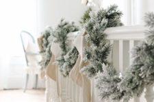 19 a snowy evergreen garland with bows is a great decoration for any space, it’s veyr easy to DIY