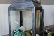 20 a lantern with ornaments, star fish, seashells and sand is a great beachy and coastal display for Christmas