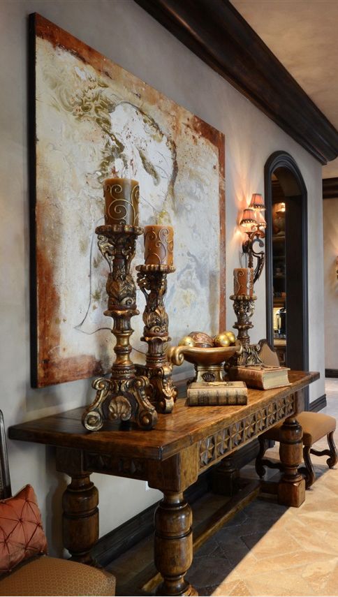 a vintage wooden table and exquisite large candle holders give this space an exquisite Mediterranean feel