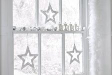 20 a window decorated in white and silver to create a winter wonderland feel in your space