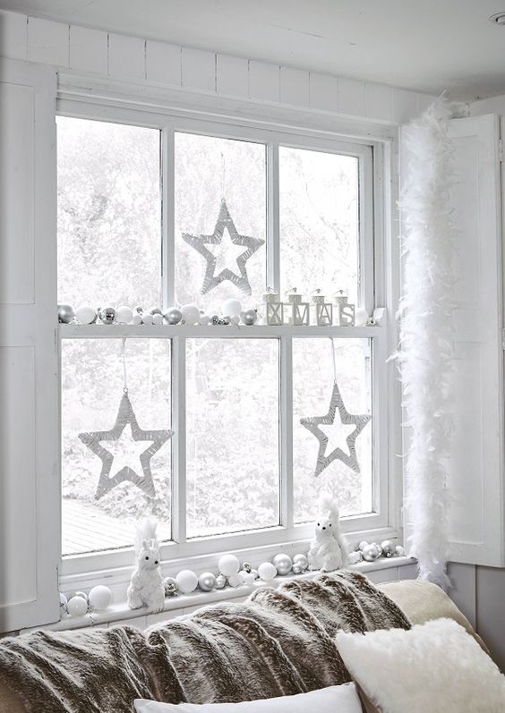 a window decorated in white and silver to create a winter wonderland feel in your space