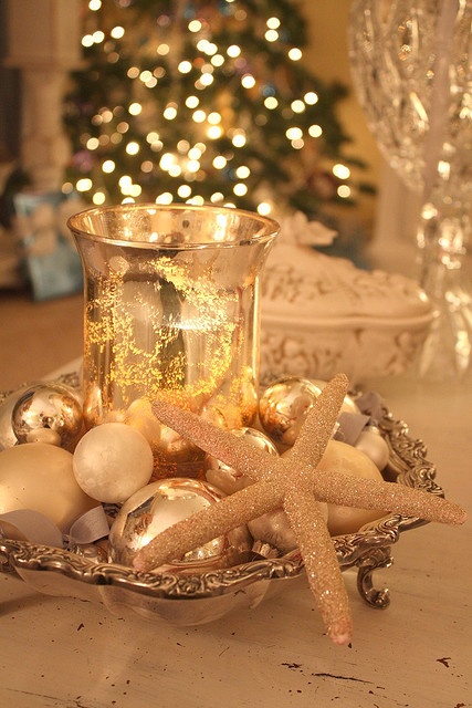 a refined display with a vintage tray, metallic ornaments, a glitter star fish and a gold leaf lantern