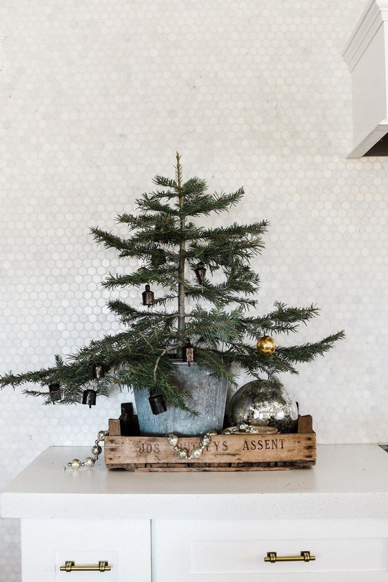 a tray with a large tree in a galvanized bucket, vintage ornaments and an oversized one