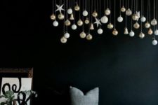 23 a branch with hanging down Christmas ornaments is a cool idea to decorate any space with modern vibes