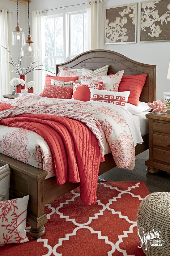a bright bedding set with coral and white and lots of different prints and matching pillows and a rug cheer up a neutral space