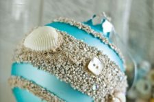 23 a turquoise Christmas ornament with beach sand, buttons and seashells can be DIYed